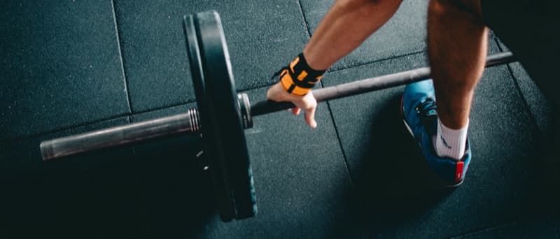 A loaded barbell on the floor of a bright airy gym