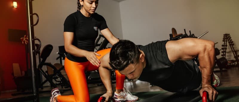 An exercise chart and light dumbbells on a bench in a rehabilitation gym