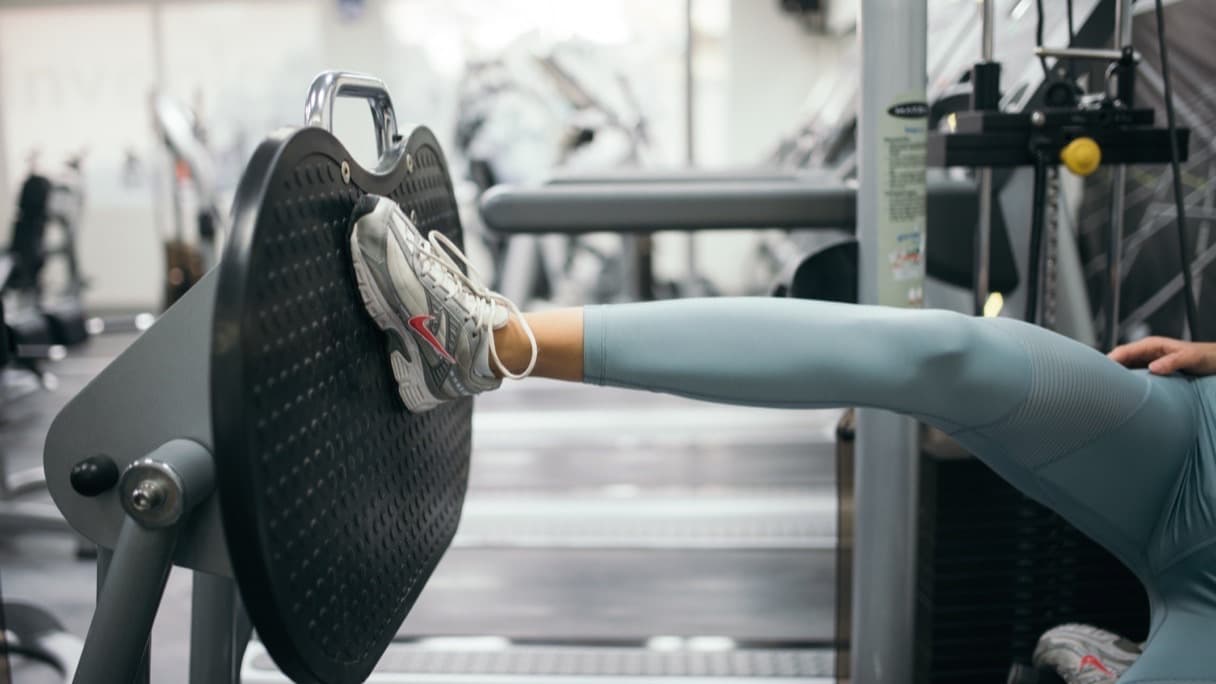 A knee support sleeve and trainers on a gym bench