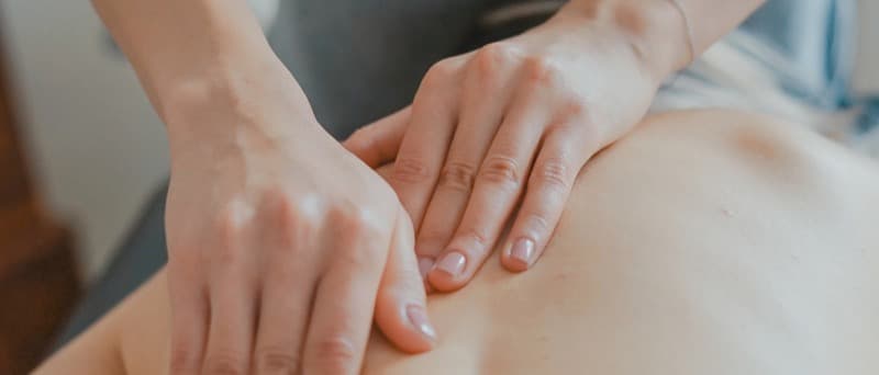 A physiotherapy treatment table made up with fresh paper in a bright clinic room